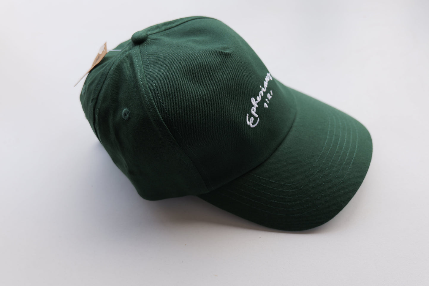 Green cap with white embroidery on a white background